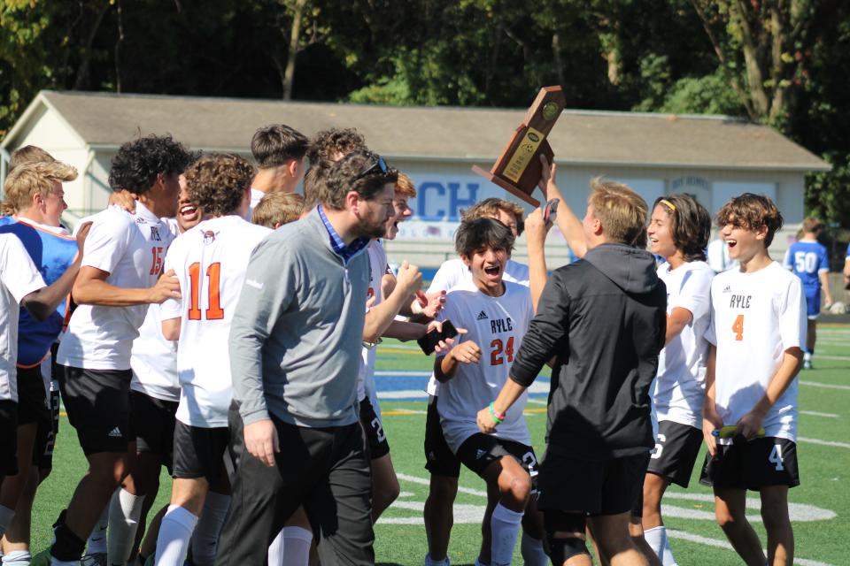 Ryle players celebrate with their championship trophy as Ryle defeated Covington Catholic 2-0 in the KHSAA 9th Region boys soccer championship game Oct. 15, 2022, at Covington Catholic High School.
