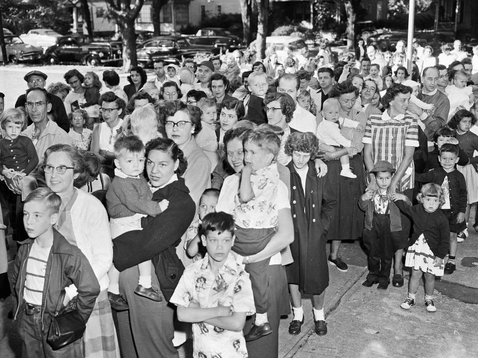 A line of children and parents wait to be immunized with gamma globulin