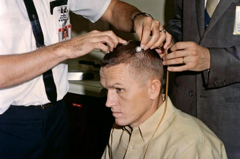 Astronaut Frank Borman, the Gemini-7 command pilot, sits attentively as two scalp electrodes are attached to his head. The electrodes allowed doctors to record electrical activity of the astronaut's cerebral cortex during periods of weightlessness. Photo courtesy of NASA