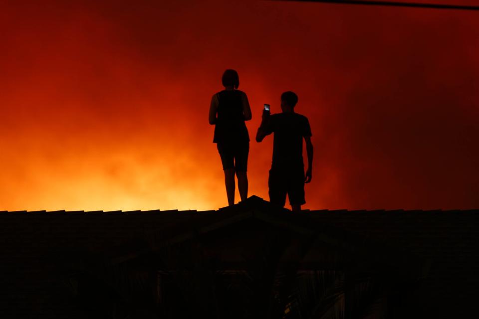 In this 2018 file photo, Redding residents look on as the Carr Fire rages.