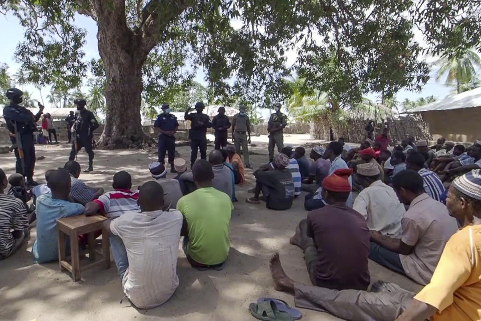 In this image made from video, Rwandan and Mozambican police speak to returnees in Palma, Cabo Delgado province, Mozambique Sunday, Aug. 15, 2021. Fleeing beheadings, shootings, rapes and kidnappings, nearly 1 million people are displaced by the Islamic extremist insurgency in northern Mozambique. (AP Photo/Marc Hoogsteyns, File)