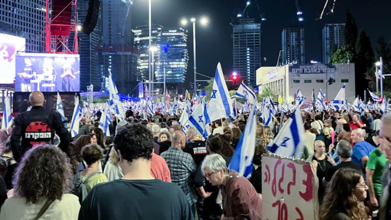 Protesters hold flags during a demonstration against Israeli Prime Minister Benjamin Netanyahu's government and call for the release of hostages held in the Gaza Strip by the Hamas militant group. Cindy Riechau/dpa