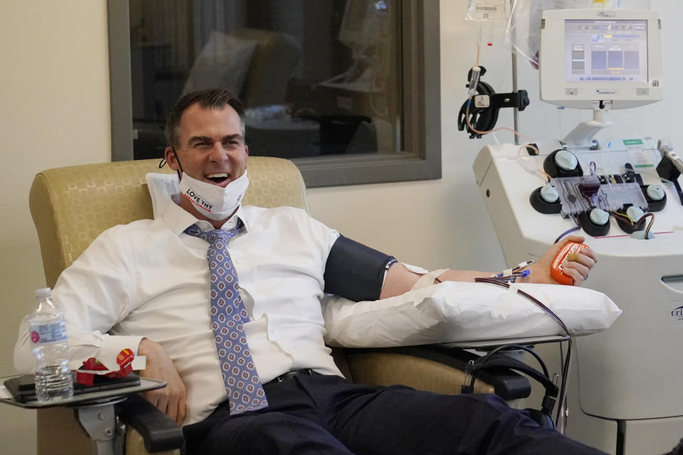 Oklahoma Gov. Kevin Stitt talks with the media as he donates convalescent plasma at the Oklahoma Blood Institute in Oklahoma City, Tuesday, Dec. 1, 2020. This is Gov. Stitt's second time donating plasma since he tested positive for the coronavirus in July. (AP Photo/Sue Ogrocki)