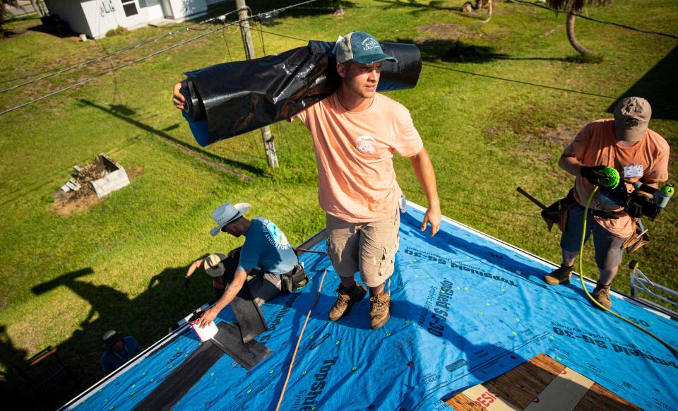 David Bryhn, a volunteer with Eight Days of Hope helps replace a roof on a home in Harlem Heights on Monday, May 22, 2023. Eight Days of Hope, a non-profit is back in Southwest Florida with  hundreds of volunteers helping families affected by Hurricane Ian.  