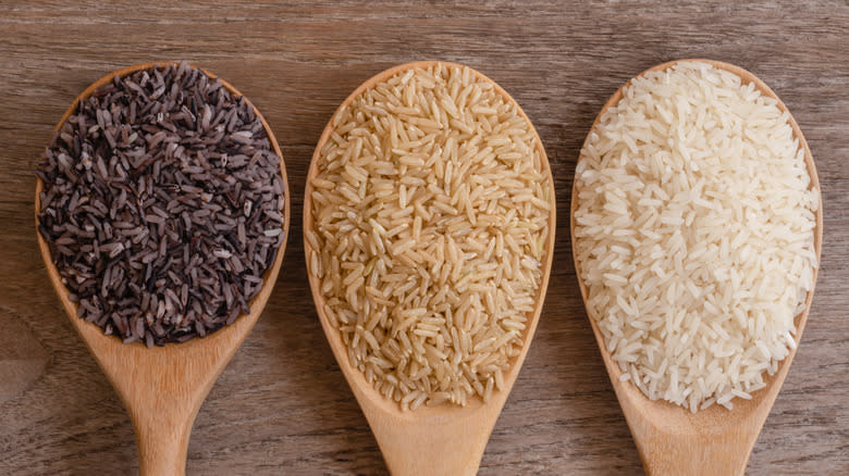 rice varieties in wooden spoons