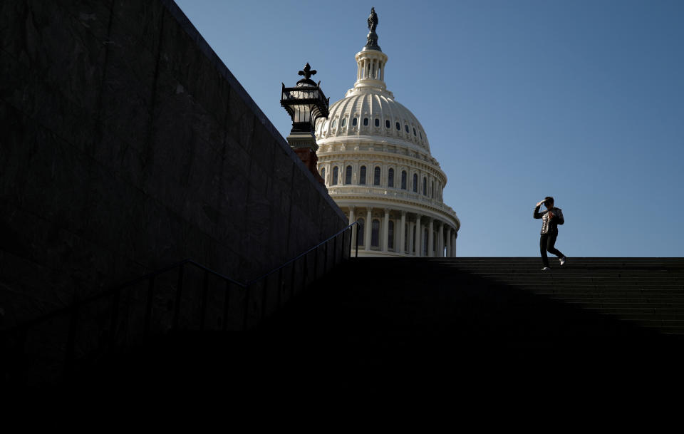 FILE PHOTO: A visitor walks outside of the U.S. Capitol before an expected House vote on appointing impeachment managers in Washington