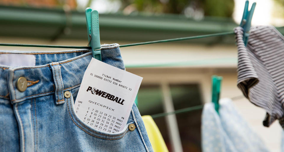 A Powerball ticket sticks out of a jeans pocket on the clothesline