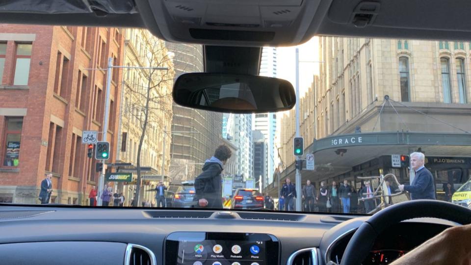 A photograph taken in Sydney's CBD from inside a car shows a man with a chair confronting the alleged stabber.