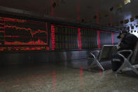 A Chinese man eats his meal at a brokerage in Beijing, China, Tuesday, Dec. 25, 2018. Japanese stocks plunged Tuesday and other Asian markets declined following heavy Wall Street losses triggered by President Donald Trump's attack on the U.S. central bank. (AP Photo/Ng Han Guan)