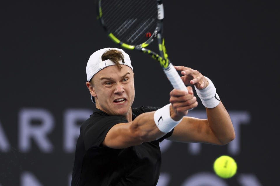 FILE - Holger Rune of Denmark plays a shot in his semifinal match against Roman Safiullin of Russia during the Brisbane International tennis tournament in Brisbane, Australia, Saturday, Jan. 6, 2024. Rune is one of the players to watch at the Australian Open. The year's first Grand Slam tennis tournament is scheduled to start at Melbourne Park on Sunday, Jan. 14. (AP Photo/Tertius Pickard, File)