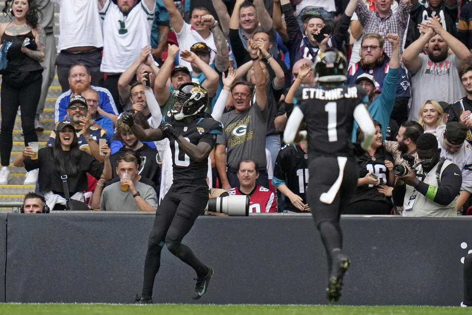 Jacksonville Jaguars wide receiver Calvin Ridley (0), left, celebrates after scoring a touchdown during the first quarter of an NFL football game between the Atlanta Falcons and the Jacksonville Jaguars at Wembley stadium in London, Sunday, Oct. 1, 2023. (AP Photo/Kirsty Wigglesworth)