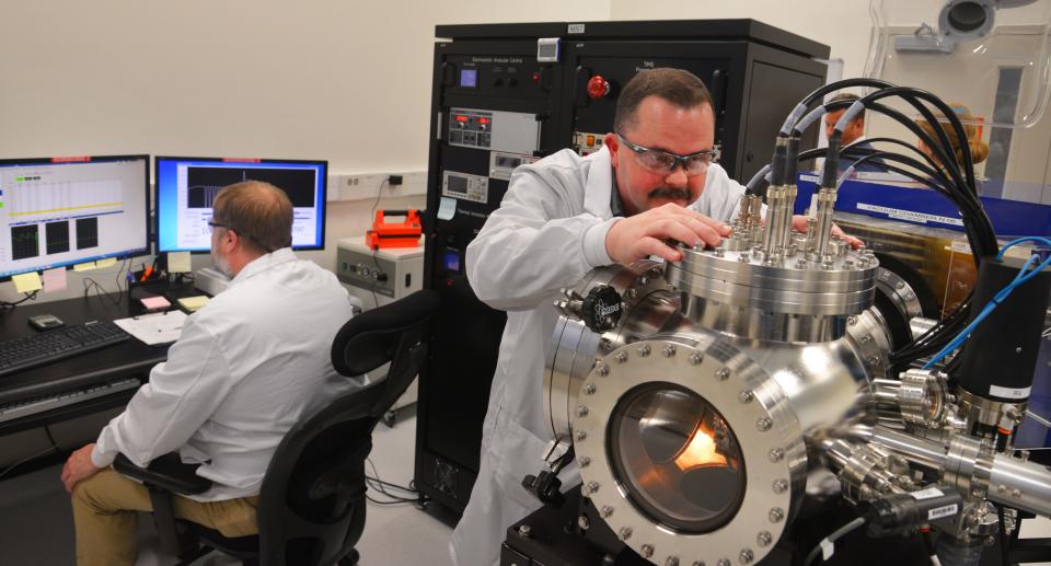 Wesley Schuler (right), flight chief for mass spectrometry, and Jason Webb, mass spectrometry technician, analyze uranium and plutonium isotopes inside an AFTAC laboratory.