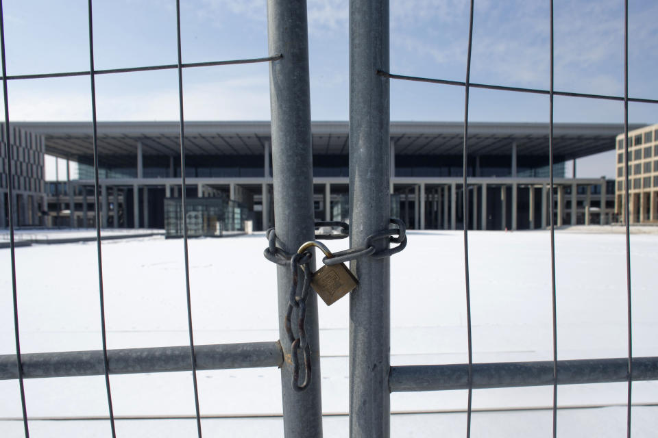 In this March 14, 2013 photo, a fence shields the main terminal of the new Berlin Brandenburg International Airport (BER) named Willy-Brandt-Flughafen in Schoenefeld near Berlin. Willy Brandt International Airport, named for Germany's famed Cold War leader, was supposed to have been up and running in late 2011, a sign of Berlin's transformation from Cold War confrontation line to world class capital of Europe's economic powerhouse. Instead it has become a symbol of how, even for this technological titan, things can go horribly wrong. After four publicly announced delays, officials acknowledged the airport won't be ready by the latest target: October 2013. To spare themselves further embarrassment, officials have refused to set a new opening date. (AP Photo/Markus Schreiber)