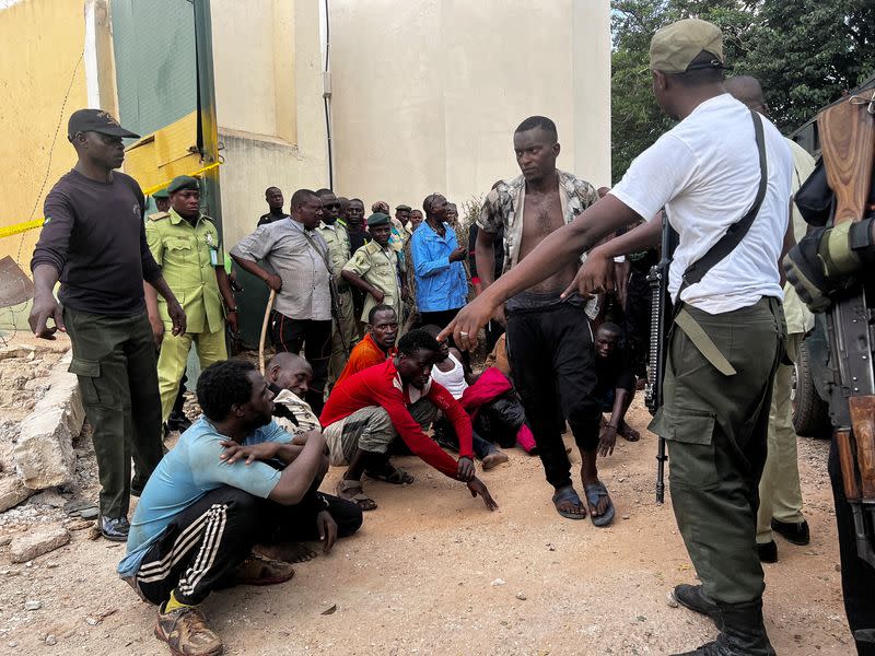 Inmates who escaped during the attack wait after being returned back to Kuje prison, in Abuja