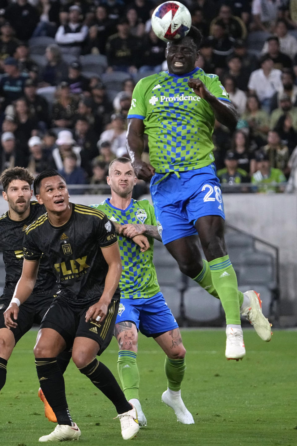 Seattle Sounders defender Yeimar Gomez, right, heads the ball as Los Angeles FC defender Denil Maldonado, second from left, watches during the first half of a Major League Soccer match Wednesday, June 21, 2023, in Los Angeles. (AP Photo/Mark J. Terrill)