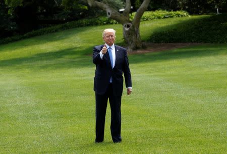 U.S. President Donald Trump stops to give a thumbs up as he departs the White House to embark on a trip to the Middle East and Europe, in Washington, U.S., May 19, 2017. REUTERS/Kevin Lamarque