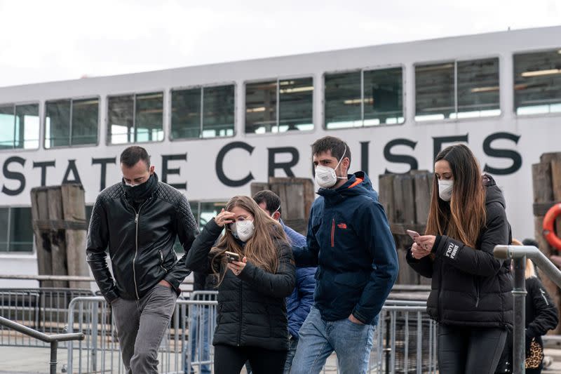 FILE PHOTO: Visitors wearing a surgical mask are seen following the outbreak of coronavirus disease (COVID-19) in New York City