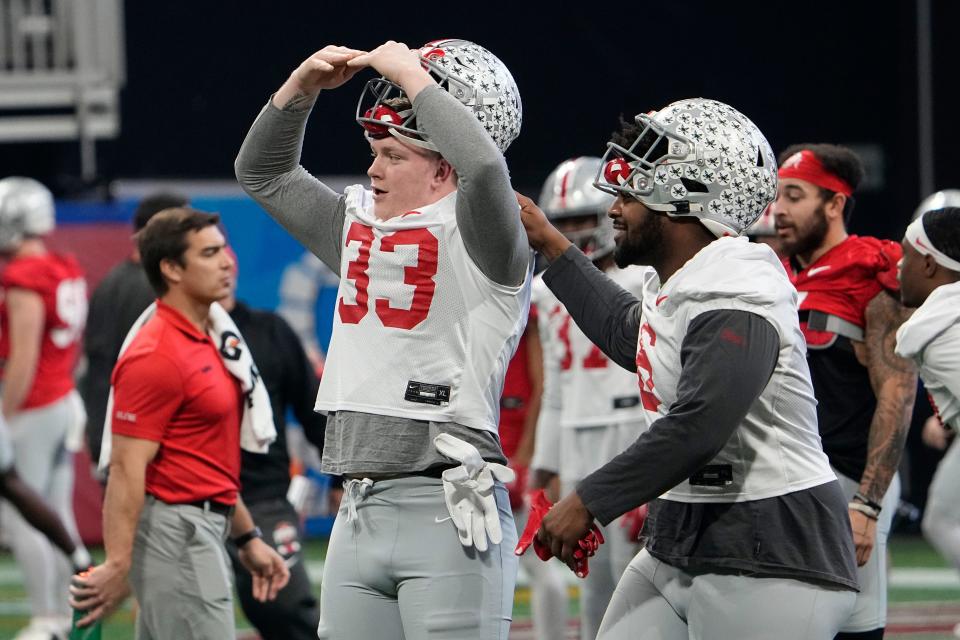 Dec 29, 2022; Atlanta, GA, USA;  Ohio State Buckeyes defensive end Jack Sawyer (33) spells out O-H-I-O with his hands as he stretches with defensive tackle Taron Vincent (6) during a team practice for the Peach Bowl game against the Georgia Bulldogs in the College Football Playoff semifinal at Mercedes Benz Stadium. Mandatory Credit: Adam Cairns-The Columbus Dispatch