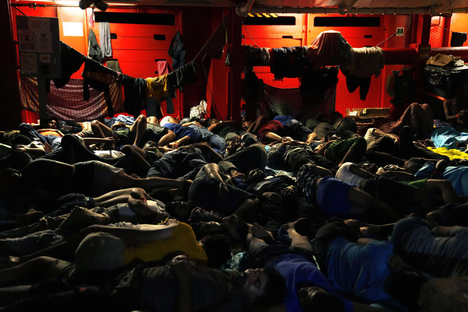 FILE - Migrants sleep on the deck of the Spanish NGO Open Arms lifeguard ship after they were rescued from open waters during an operation in the international waters zone, on the Mediterranean sea, Sept. 20, 2022. The back-to-back shipwrecks of migrant boats off Greece that left at least 22 people dead this week has once again put the spotlight on the dangers of the Mediterranean migration route to Europe. (AP Photo/Petros Karadjias, file)