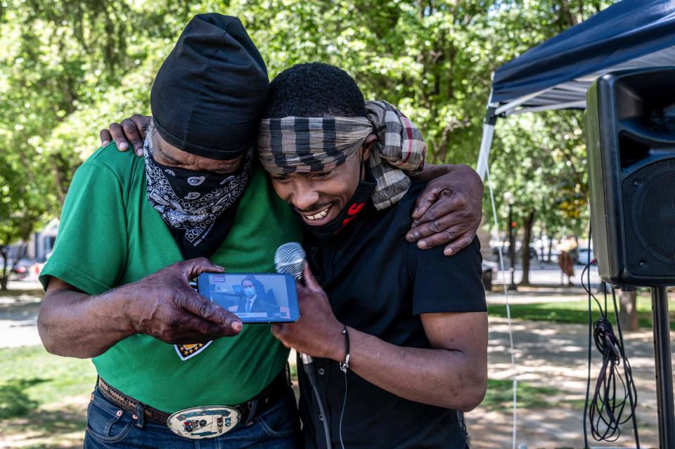 Stevante Clark, right, brother of Stephon Clark who was fatally shot by Sacramento Police, is hugged by his cousin Steven Ray Collins, left, at Cesar Chavez Park in Sacramento, California Tuesday as they listen live to the guilty verdict of former Minneapolis police Officer Derek Chauvin for the murder of George Floyd. A jury convicted Chauvin on murder and manslaughter charges.