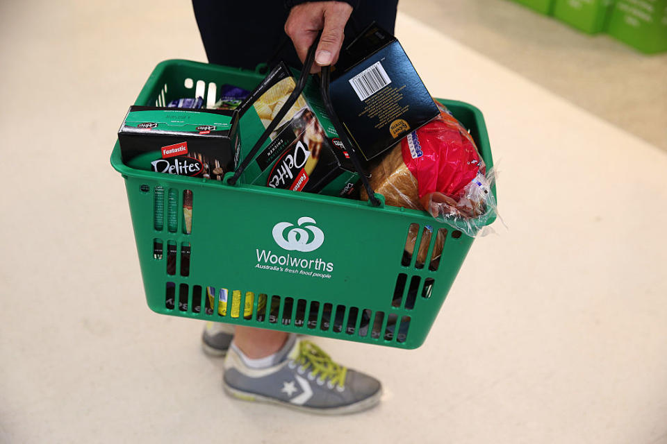 A customer carries a laden shopping basket at a Woolworths in Sydney.