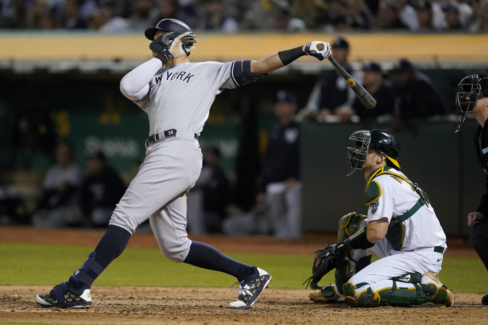 New York Yankees' Aaron Judge, left, hits a three-run home run in front of Oakland Athletics catcher Sean Murphy during the fifth inning of a baseball game in Oakland, Calif., Friday, Aug. 26, 2022. (AP Photo/Jeff Chiu)