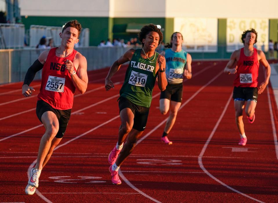 New Smyrna Beach's Brett Remensnyder and Flagler Palm Coast's Kamron Davis round the corner in the first heat of the 400-meter dash at the Five Star Conference track and field championships.