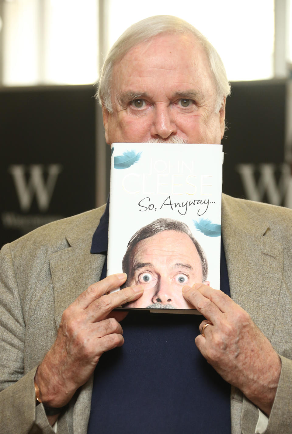 British comedian John Cleese poses with a copy of his autobigraphy, <em>So, Anyway…</em>, at a book signing in London in 2014. (Photo by Joel Ryan/Invision/AP)