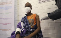 FILE - In this June 24, 2020 file photo, a vaccine volunteer receives an injection at the Chris Hani Baragwanath hospital in Soweto, Johannesburg. The country's success in bringing its first wave of COVID-19 under control has allowed it to almost fully reopen the economy, while monitoring for signs of a second surge, says the government's chief medical advisor. (Siphiwe Sibeko/Pool photo via AP, file)