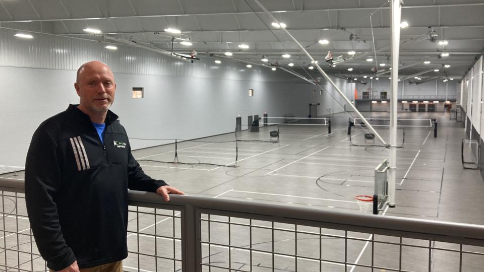 Scott Rodgers, general manager of Spooky Nook Champion Mill in Hamilton, poses in front of the new volleyball and basketball courts