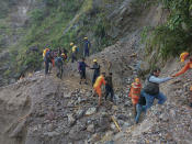 This photograph provided by India’s National Disaster Response Force (NDRF) shows NDRF personnel rescuing civilians stranded following heavy rains at Chhara village near Nainital, Uttarakhand, Wednesday, Oct. 20, 2021. Nainital remained cut off from the rest of the state as roads leading to it were either blocked by landslides or washed away. ( National Disaster Response Force via AP)