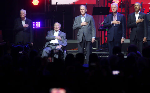 Former Presidents from right, Barack Obama, Bill Clinton, George W. Bush, George H.W. Bush and Jimmy Carter place their hands on their chest for the national anthem - Credit: LM Otero/AP