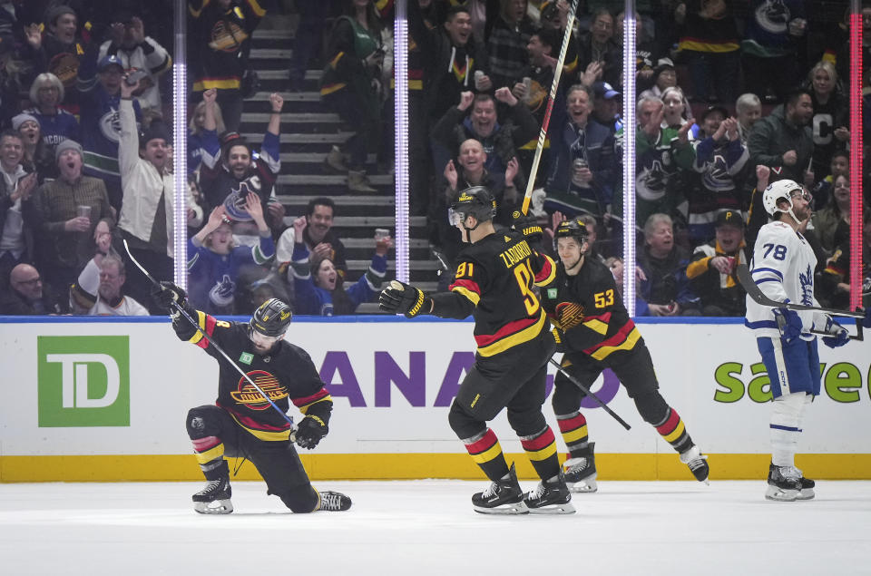 Vancouver Canucks' Conor Garland (8), Nikita Zadorov (91) and Teddy Blueger (53) celebrate after Garland's goal as Toronto Maple Leafs' T.J. Brodie (78) looks on during the first period of an NHL hockey game in Vancouver, British Columbia, Saturday, Jan. 20, 2024. (Darryl Dyck/The Canadian Press via AP)