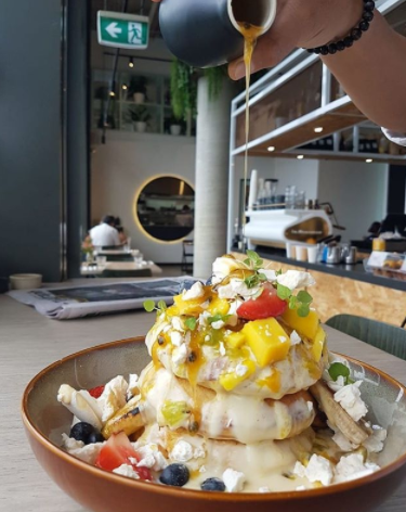 The Pavlova Pancakes feature chunks of sugary pavlova, fresh fruit salad, passionfruit syrup and creamy custard. Photo: Left of Field Instagram