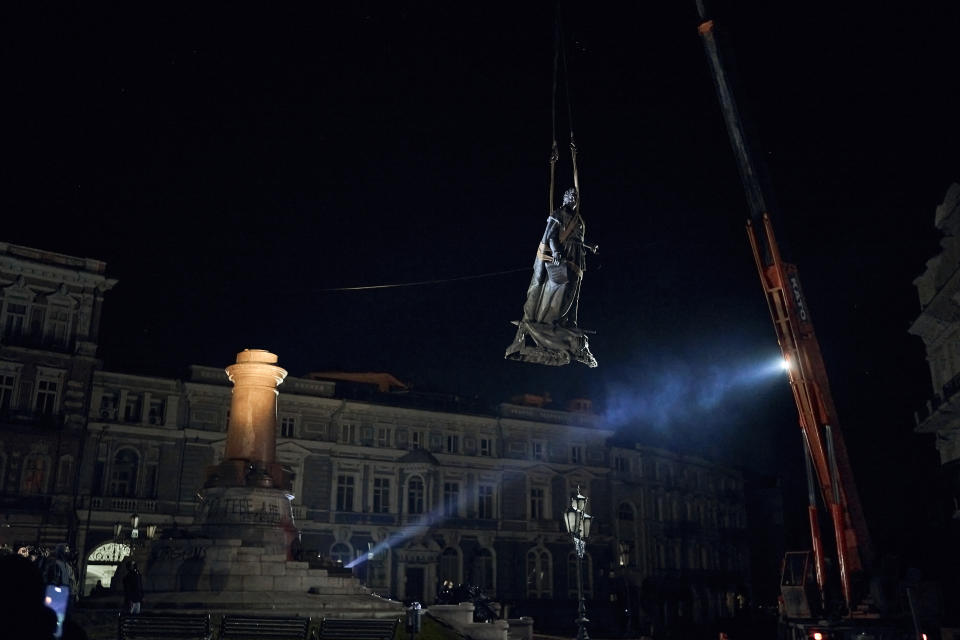 Workers remove the monument to Catherine II, also known as the "Monument to the Founders of Odesa" in Odesa, Ukraine, early Thursday, Dec. 29, 2022. The decision to dismantle the monument consisting of sculptures of Russian Empress Catherine II and her associates was made recently by Odesa residents by electronic voting. (AP Photo/LIBKOS)
