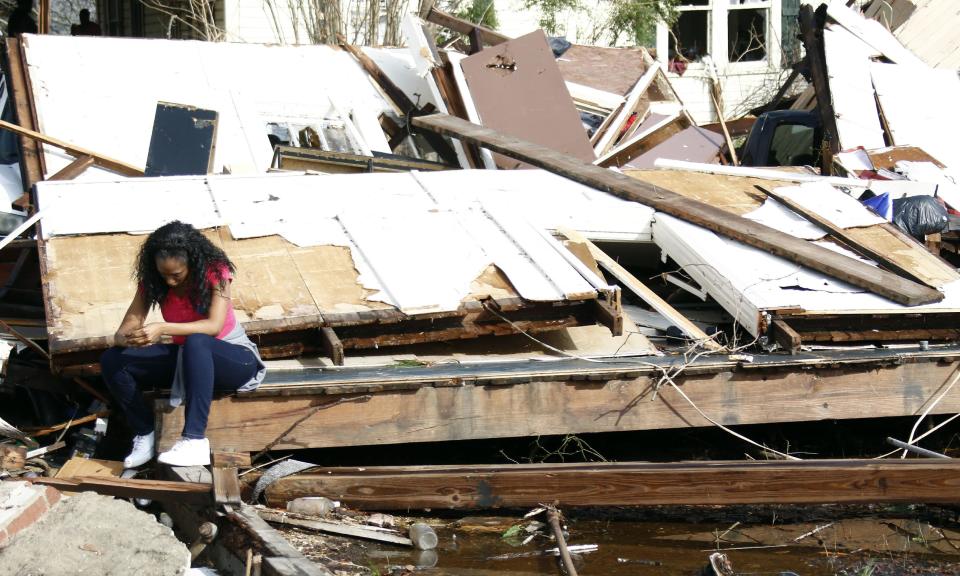 Shanise McMorris grieves on the slab of her Hattiesburg, Miss., home after an early tornado hit the city, Saturday, Jan. 21, 2017. Neither she or her husband or two children were injured when the roof collapsed on them. The tornado was part of a wall of stormy weather traveling across the region, bringing with it rain and unstable conditions. (AP Photo/Rogelio V. Solis)