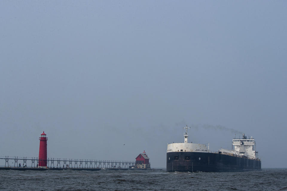 Smoky air over the south pier in Grand Haven, Mich., as the John J. Boland, a diesel-powered freighter, leaves port on Tuesday, June 27, 2023. The National Weather Service has issued air quality alerts for all of Michigan, effective until tomorrow morning, due to the smoke from Canadian wildfires. (Cory Morse/MLive.com/The Grand Rapids Press via AP)