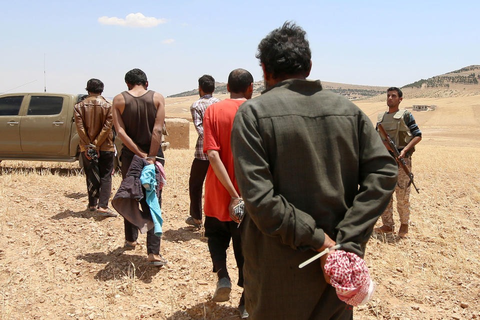 <p>Men, who the Democratic Forces of Syria fighters claimed were Islamic State fighters, walk as they are taken prisoners after SDF advanced in the southern rural area of Manbij, in Aleppo Governorate, Syria May 31, 2016. (REUTERS/Rodi Said) </p>