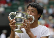 Japan's Shintaro Mochizuki kisses the trophy after defeating Spain's Carlos Gimeno Valero during the boys' singles final match of the Wimbledon Tennis Championships in London, Sunday, July 14, 2019. (AP Photo/Kirsty Wigglesworth)