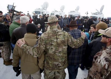 A militiaman embraces Ammon Bundy (2nd R) after Bundy spoke to the media at the Malheur National Wildlife Refuge near Burns, Oregon, in this January 4, 2016 file photo. REUTERS/Jim Urquhart/Files