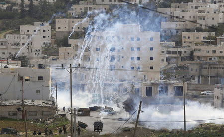 Israeli troops fire tear gas towards Palestinians gathering near the scene of what the Israeli army said was a suspected Palestinian stabbing attack, at the West Bank Al-Fawwar refugee camp, south of Hebron November 25, 2015. REUTERS/Mussa Qawasma