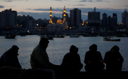 People rest as they wait for fishermen to come back with their catch, after Israel expanded fishing zone for Palestinians, at the seaport of Gaza City April 2, 2019. REUTERS/Suhaib Salem