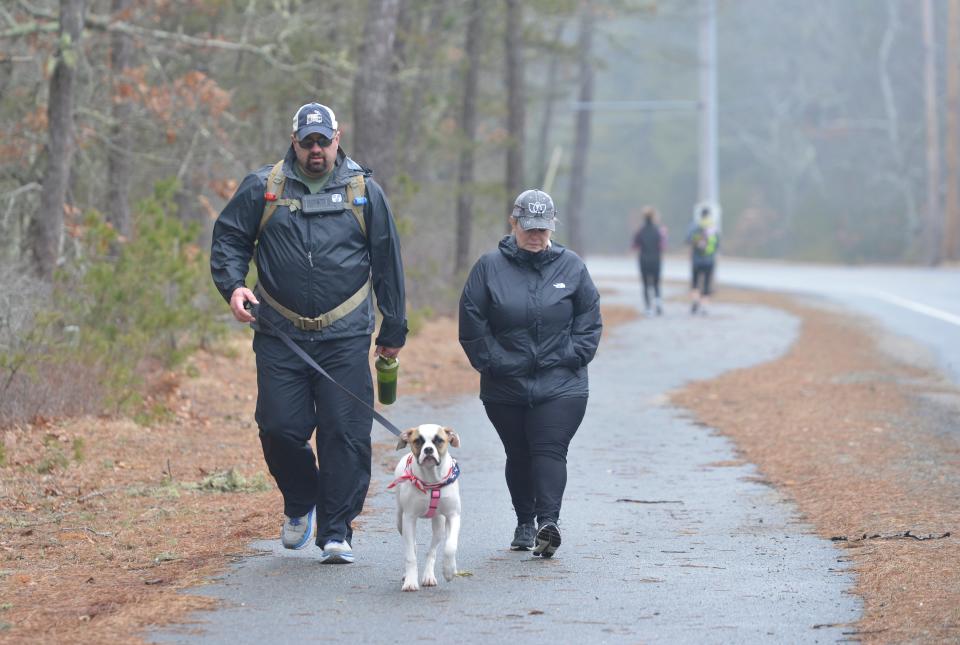 Heroes in Transition Veterans Coordinator John Alexander, of Sandwich, left, and his wife, Kristen Alexander, and dog, Bella, make their way along Great Neck Road South. He has participated in the Ruck4HIT since it started in 2016. His wife will be participating in the Ruck4HIT as one of the support drivers.