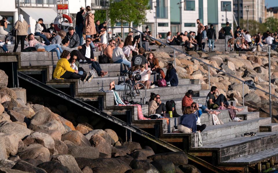 People enjoy the warm evening at Sundspromenaden in Malmo, Sweden - Shutterstock