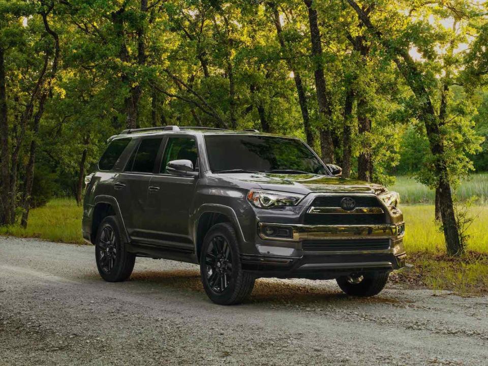 A dark-gray 2019 Toyota 4Runner on a tree-lined road.