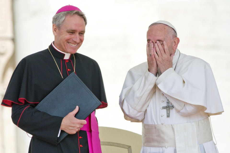 FILE - Pope Francis touches his face as he shares a word with Archbishop Georg Gaenswein at the end of weekly general audience in St. Peter's Square at the Vatican, Wednesday, May 25, 2016. Pope Francis met on Monday, Jan. 9, 2023, with Archbishop Gaenswein, the longtime secretary of Pope Benedict XVI who was a key figure in his recent funeral but who has raised eyebrows with an extraordinary memoir in which he settles old scores and reveals palace intrigue. (AP Photo/Alessandra Tarantino, File)