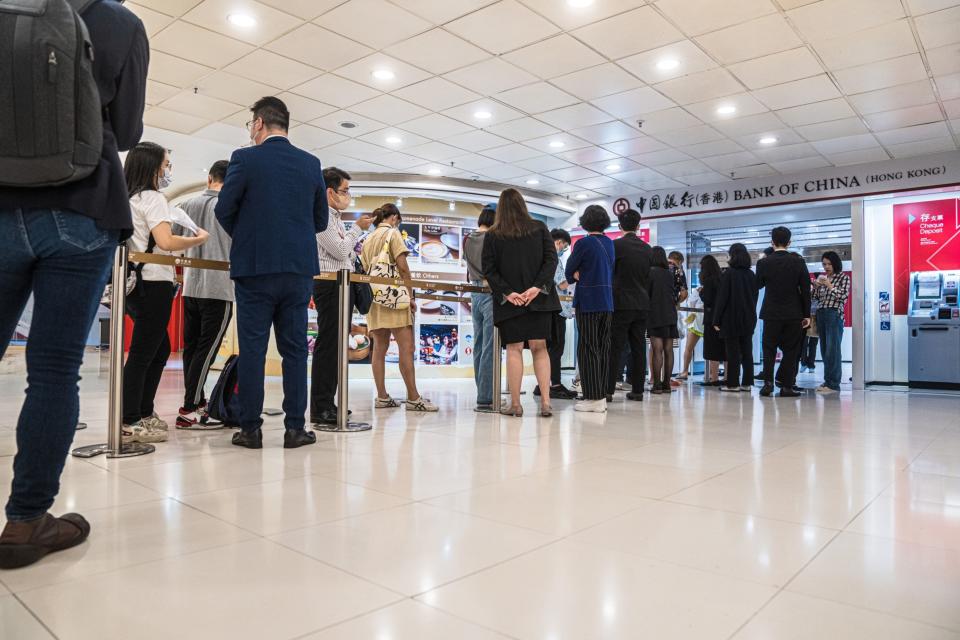 Customers queue outside a Bank of China Ltd. branch ahead of its opening hours in May. (Lam Yik/Bloomberg)
