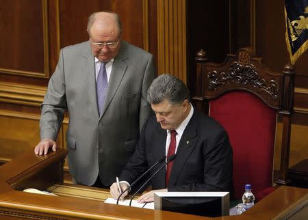 Ukraine's President Petro Poroshenko signs a landmark association agreement with the European Union during a session of the parliament in Kiev, September 16, 2014. REUTERS/Valentyn Ogirenko