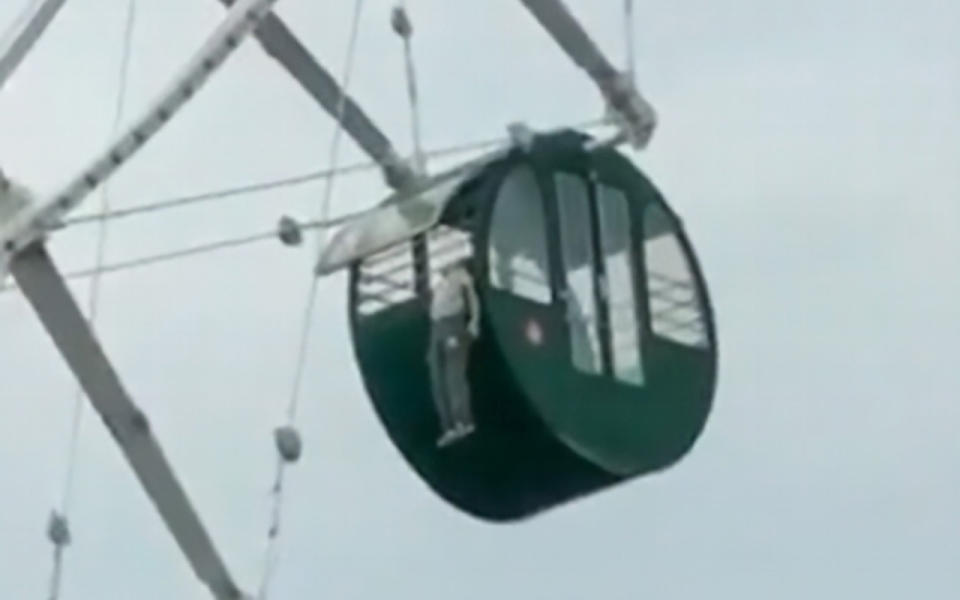 The boy is said to have tried to sit on the metal bars securing the open window of the Ferris wheel cabin when he slipped and nearly plunged some 40 metres. Image: Asia Wire