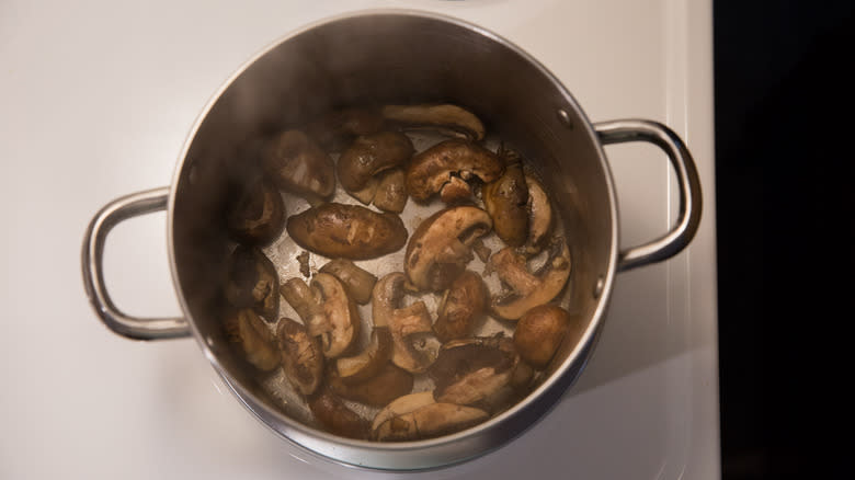 cremini mushrooms cooking in pan 